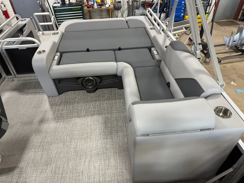 Slide: The Image of 2025 Tahoe Sport 2385 Swingback interior with gray seating and cup holders in a workshop setting. - 18