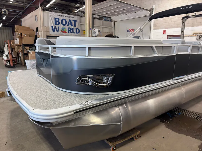 Slide: The Image of 2025 Tahoe Sport 2385 Swingback pontoon boat in showroom, featuring sleek design and modern amenities. - 34