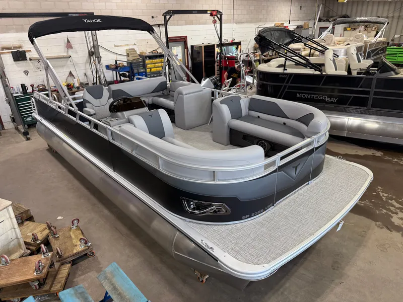 Slide: The Image of 2025 Tahoe Sport 2385 Swingback pontoon boat in showroom, featuring Honda 4-Stroke EFI engine. - 41