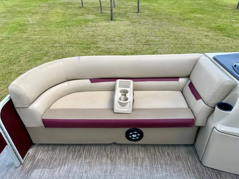 Slide: The Image of 2022 Godfrey Sweetwater 2286 C pontoon boat seating with cup holders, on grassy background. - 17