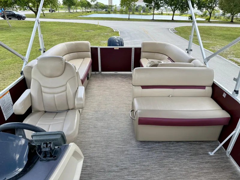 Slide: The Image of 2022 Godfrey Sweetwater 2286 C pontoon boat interior with beige seating and steering console. - 18