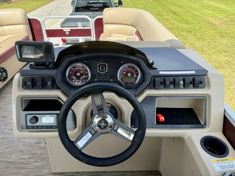 Slide: The Image of 2022 Godfrey Sweetwater 2286 C boat dashboard with steering wheel and control panel. - 22