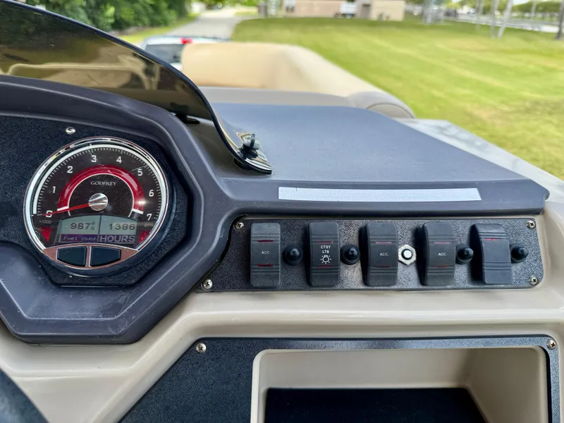 Slide: The Image of Dashboard of a 2022 Godfrey Sweetwater 2286 C boat with gauges and switches. - 25