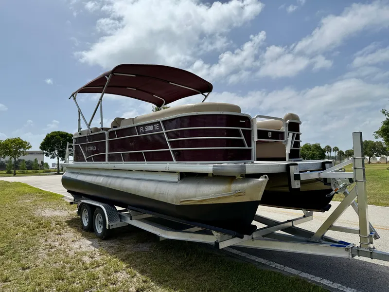 Slide: The Image of 2022 Godfrey Sweetwater 2286 C pontoon boat on trailer under blue sky. - 3