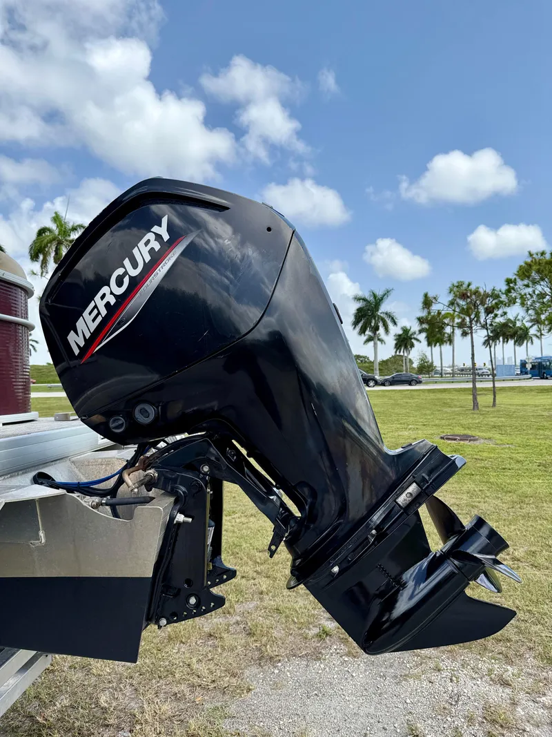 Slide: The Image of Mercury outboard motor on 2022 Godfrey Sweetwater 2286 C boat, sunny day, palm trees background. - 30