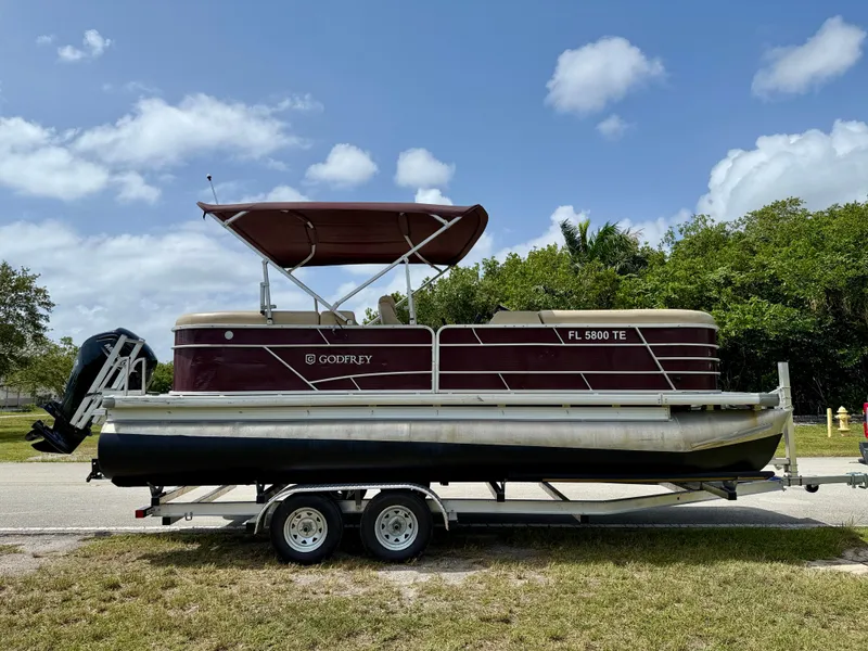Slide: The Image of 2022 Godfrey Sweetwater 2286 C pontoon boat on trailer, parked outdoors. - 4