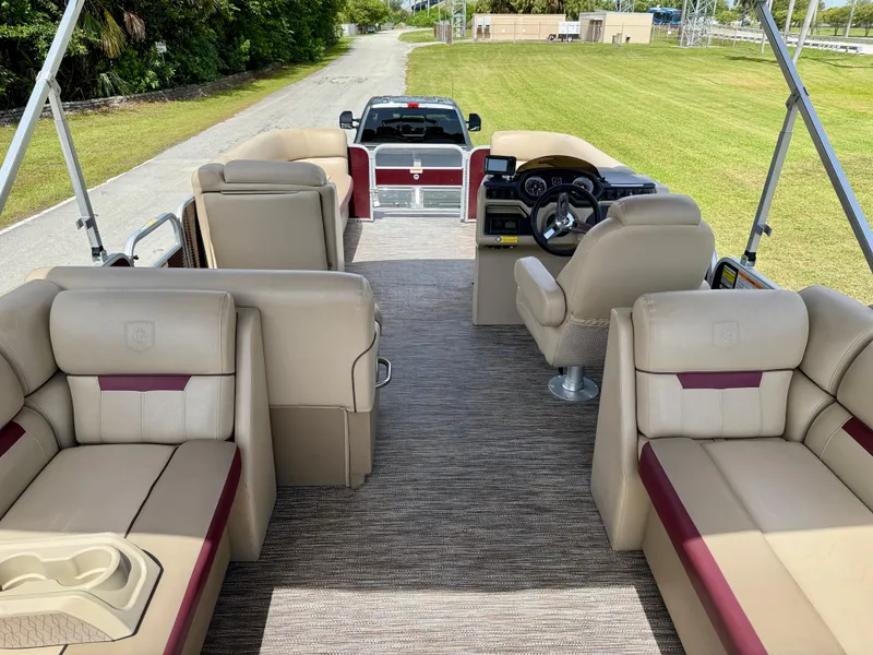 Slide: The Image of 2022 Godfrey Sweetwater 2286 C pontoon boat interior with beige seating and steering console. - 9