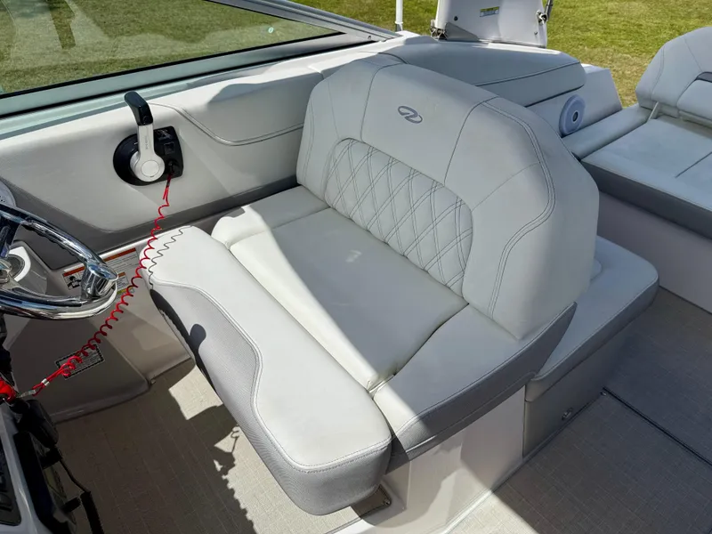 Slide: The Image of 2021 Regal 26 XO boat interior with plush seating and steering wheel. - 11
