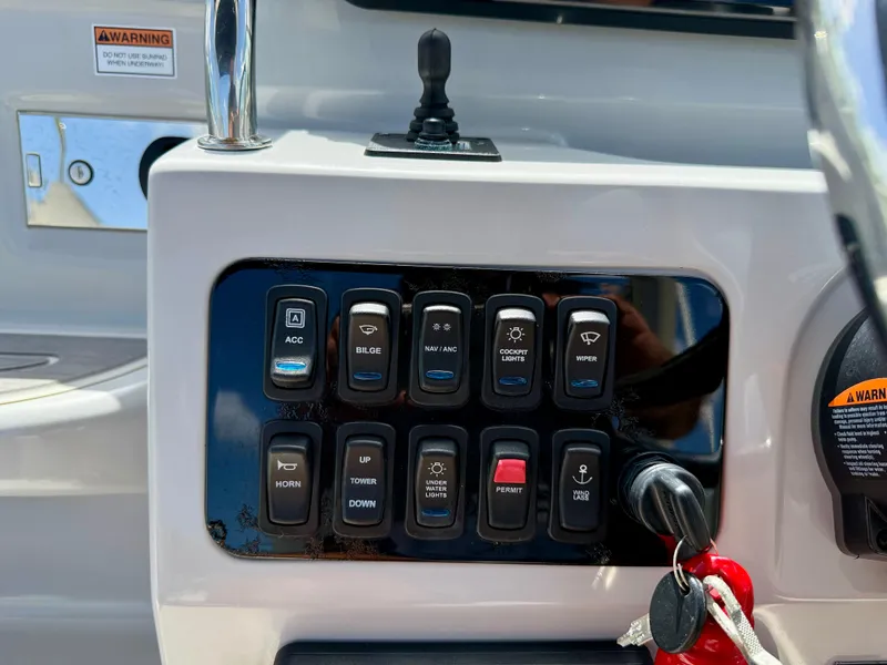 Slide: The Image of Control panel of a 2021 Regal 26 XO boat with various switches and keys. - 24