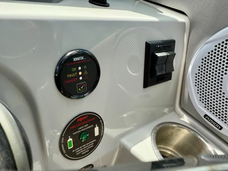 Slide: The Image of 2021 Regal 26 XO boat dashboard with gasoline fume detector and fire extinguisher controls. - 27