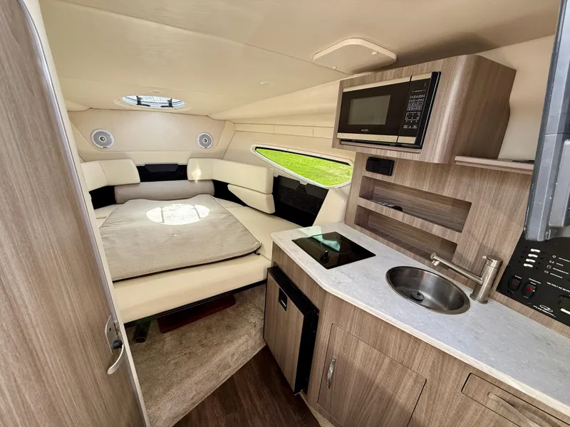 Slide: The Image of 2021 Regal 26 XO boat interior with kitchenette, bed, and modern amenities. - 29