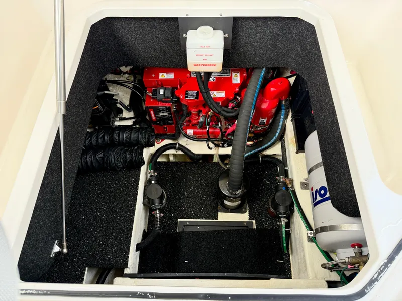 Slide: The Image of Engine compartment of a 2021 Regal 26 XO boat, featuring mechanical components and wiring. - 44