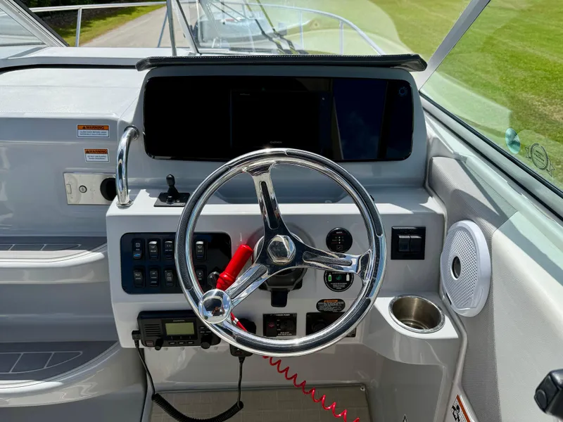 Slide: The Image of 2021 Regal 26 XO boat dashboard with steering wheel and control panel. - 8