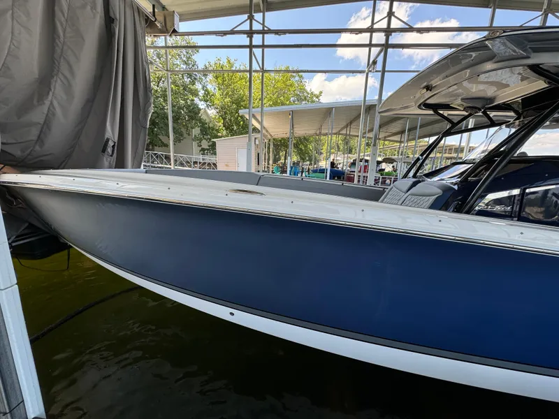 Slide: The Image of 2019 Nor-Tech 390 Sport Center Console boat docked under a canopy. - 21