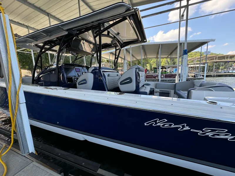 Slide: The Image of 2019 Nor-Tech 390 Sport Center Console boat docked under a covered marina. - 22