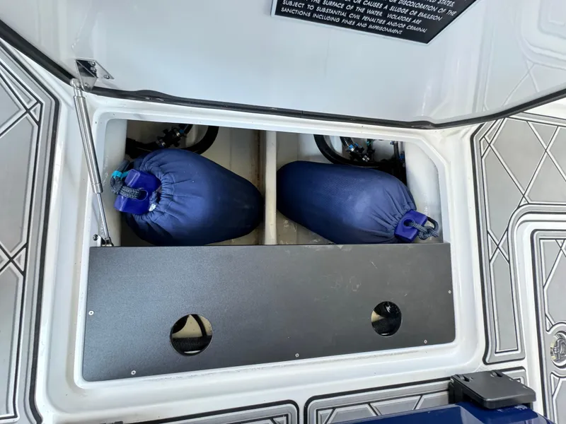 Slide: The Image of Storage compartment of 2019 Nor-Tech 390 Sport Center Console with blue bags inside. - 24
