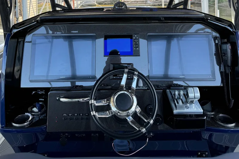 Slide: The Image of 2019 Nor-Tech 390 Sport Center Console dashboard with dual Garmin screens and steering wheel. - 37