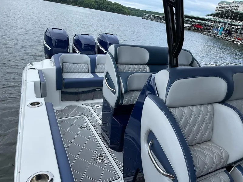 Slide: The Image of 2019 Nor-Tech 390 Sport Center Console boat with luxurious seating and Mercury engines on a lake. - 4