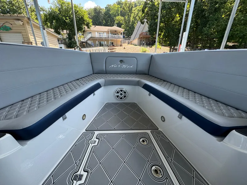 Slide: The Image of 2019 Nor-Tech 390 Sport Center Console boat interior with gray seating and patterned flooring. - 7