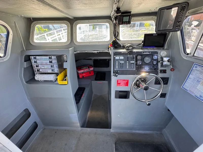 Slide: The Image of Interior of a 1992 Anderson 26 boat cockpit with navigation equipment and storage compartments. - 13