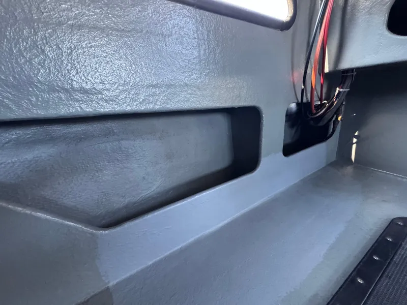 Slide: The Image of Interior of a 1992 Anderson 26 boat, featuring gray textured surfaces and wiring. - 16