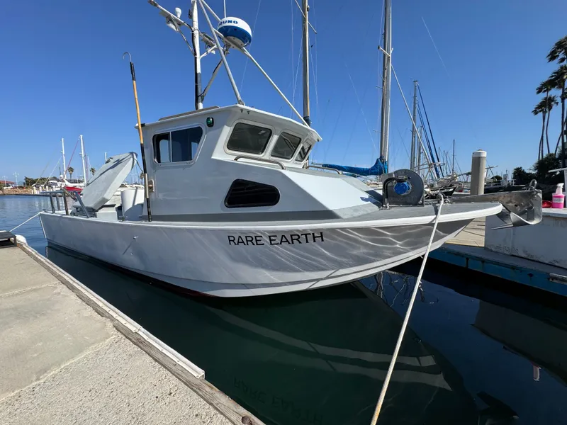 Slide: The Image of White Anderson 26 boat named "Rare Earth" docked at marina, clear blue sky. - 2