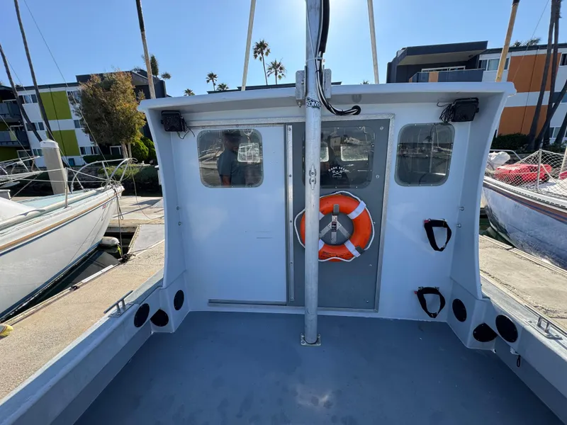Slide: The Image of Anderson 26 boat from 1992 docked, featuring a life preserver and cabin windows. - 6