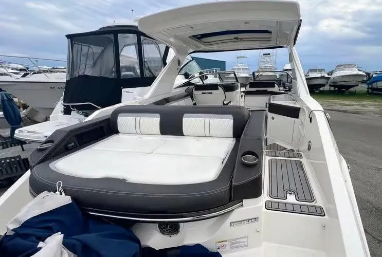 Slide: The Image of 2016 Sea Ray 310 SLX boat with spacious seating and sleek design at a marina. - 4