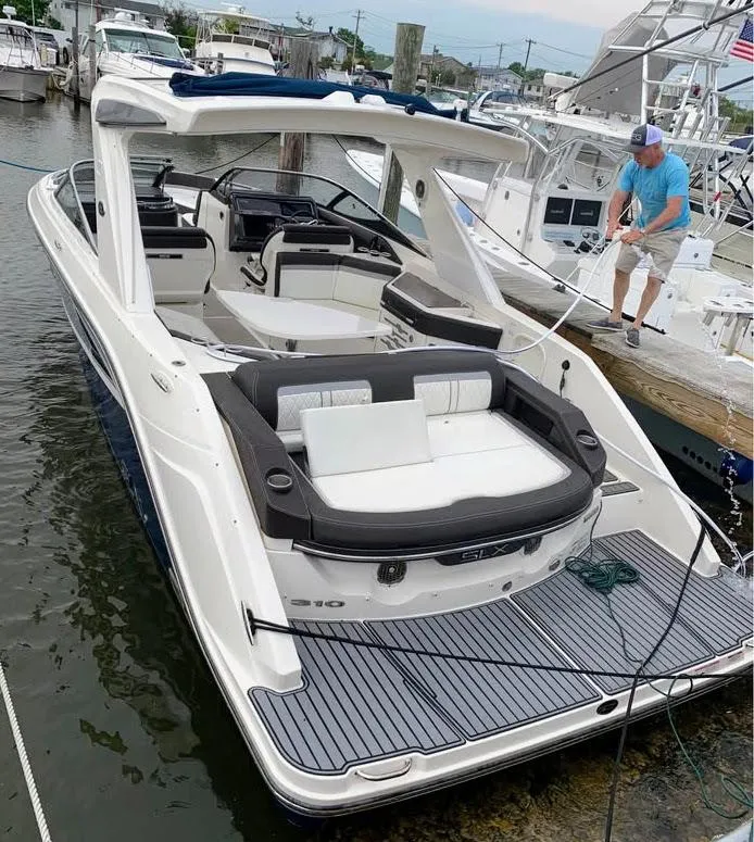 Slide: The Image of 2016 Sea Ray 310 SLX boat docked, featuring spacious seating and sleek design. - 5