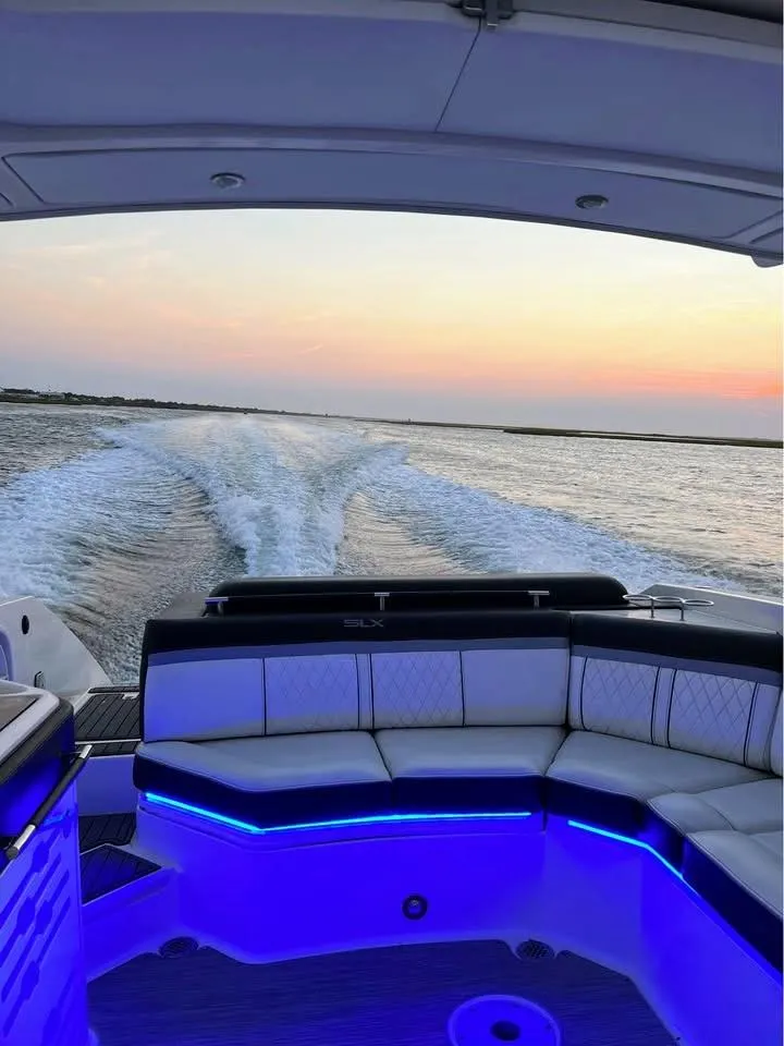 Slide: The Image of 2016 Sea Ray 310 SLX boat cruising at sunset with illuminated seating. - 9