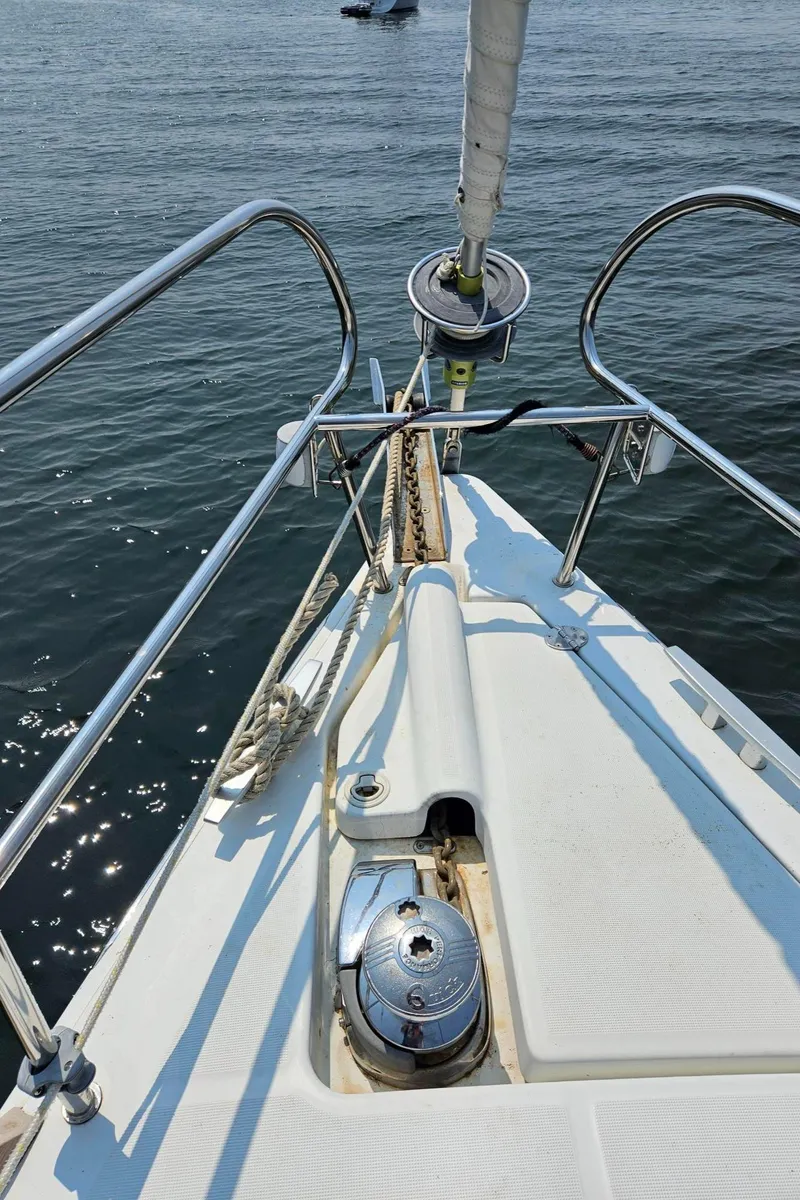 Slide: The Image of Bow of 2012 Beneteau Oceanis 37 sailboat with anchor and railing, on calm water. - 10