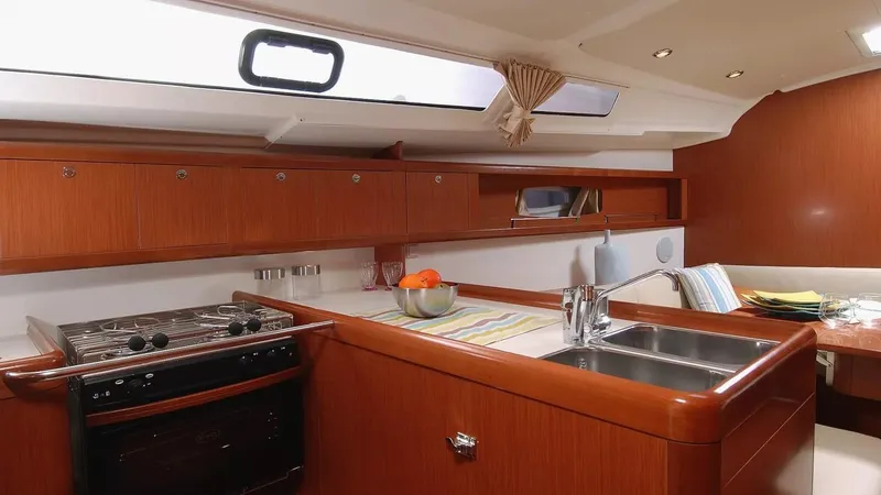 Slide: The Image of Interior of 2012 Beneteau Oceanis 37 yacht kitchen with wood finish and modern amenities. - 15