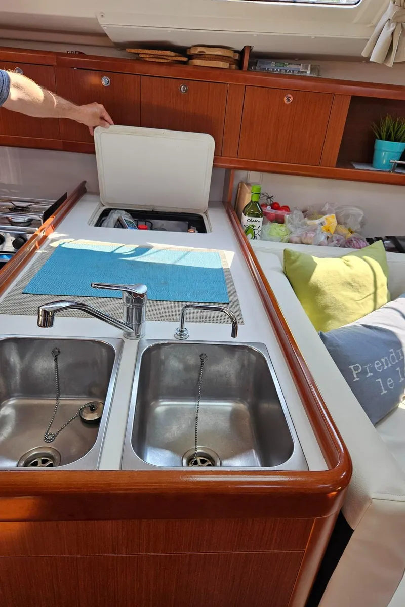 Slide: The Image of Interior of 2012 Beneteau Oceanis 37 yacht kitchen with dual sinks and wooden cabinetry. - 18
