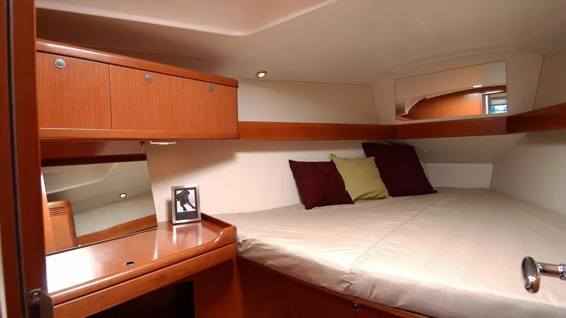 Slide: The Image of Cozy cabin interior of 2012 Beneteau Oceanis 37 with wooden cabinetry and comfortable bedding. - 28