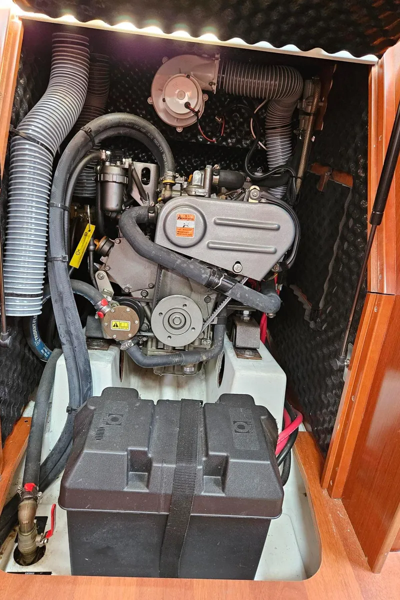 Slide: The Image of Engine compartment of a 2012 Beneteau Oceanis 37 sailboat, featuring mechanical components and hoses. - 31