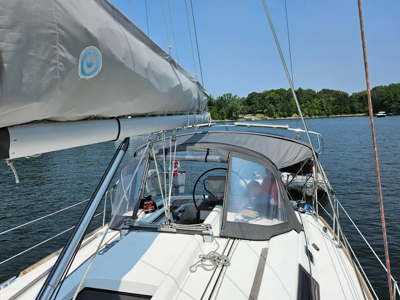 Slide: The Image of 2012 Beneteau Oceanis 37 sailboat on calm water, featuring a covered cockpit and clear skies. - 4