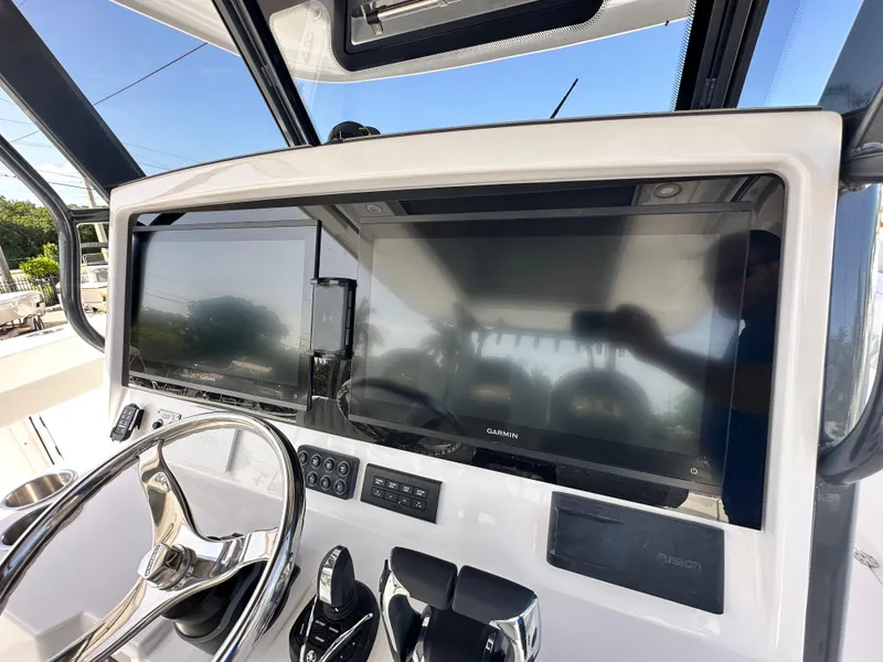 Slide: The Image of 2026 Twin Vee 400 GFX2 CC boat dashboard with dual Garmin displays and steering wheel. - 13