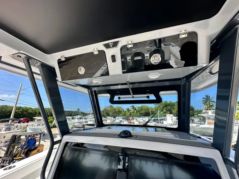 Slide: The Image of 2026 Twin Vee 400 GFX2 CC boat interior with modern dashboard and overhead storage. - 16