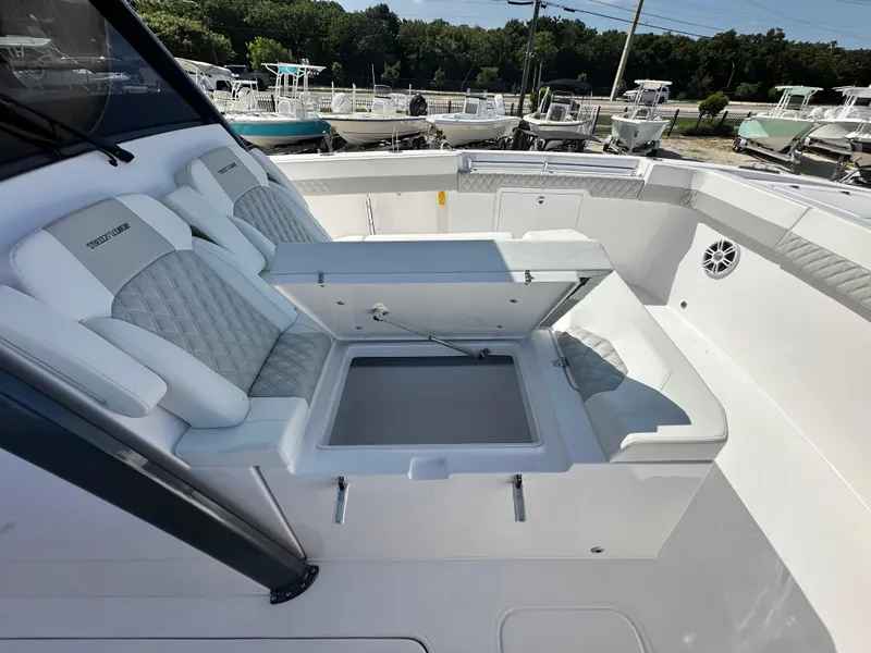 Slide: The Image of 2026 Twin Vee 400 GFX2 CC boat interior with open storage compartment and cushioned seating. - 18