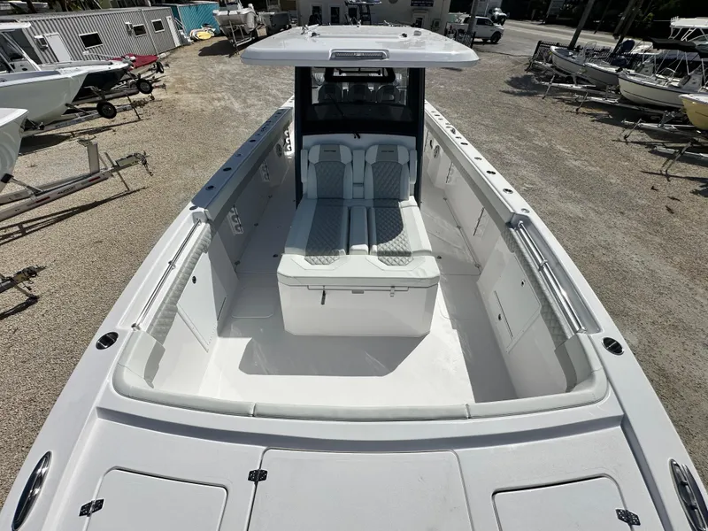 Slide: The Image of 2026 Twin Vee 400 GFX2 CC boat, spacious deck, modern design, parked in a marina. - 21