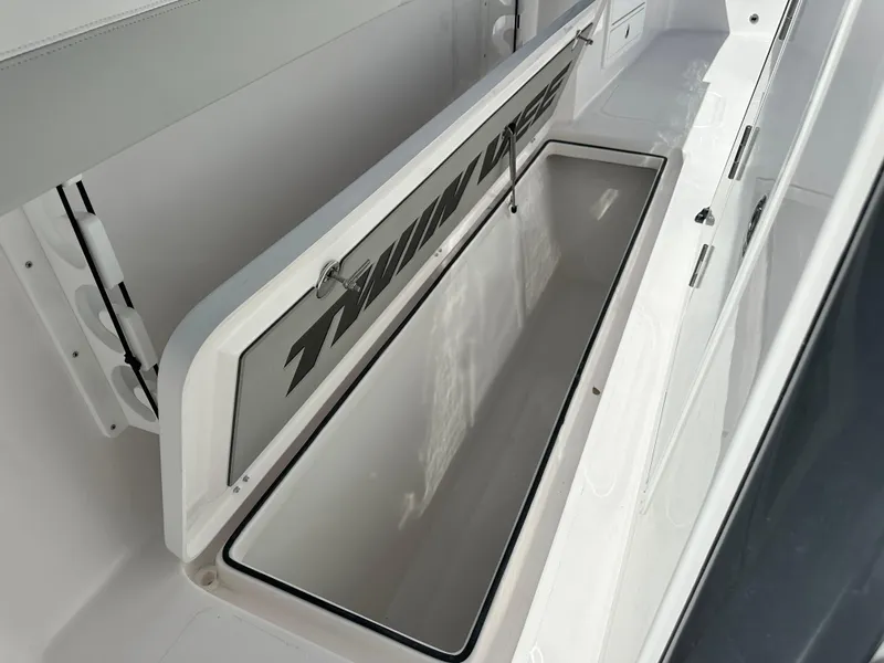 Slide: The Image of 2026 Twin Vee 400 GFX2 CC boat storage compartment, open lid, white interior. - 28