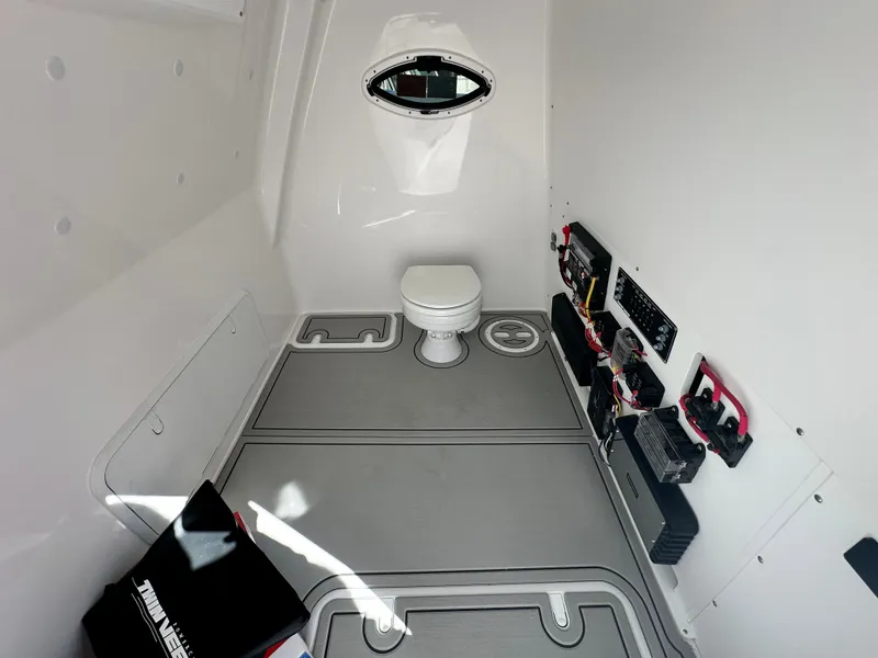 Slide: The Image of Interior of 2026 Twin Vee 400 GFX2 CC boat, featuring a compact marine toilet. - 29