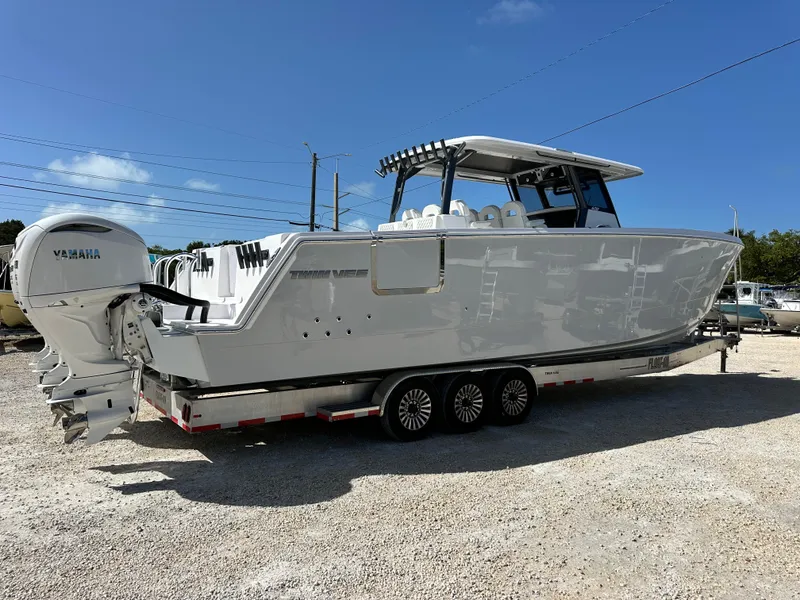 Slide: The Image of 2026 Twin Vee 400 GFX2 CC boat on trailer, featuring Yamaha engines, under clear blue sky. - 5