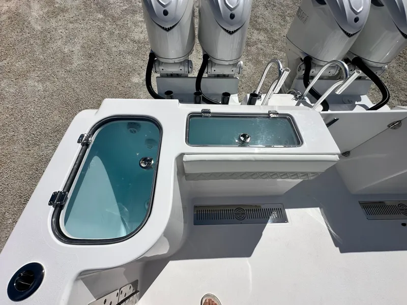 Slide: The Image of 2026 Twin Vee 400 GFX2 CC boat deck with live wells and triple outboard motors. - 7