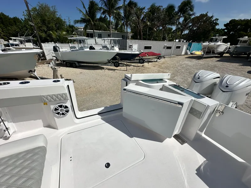 Slide: The Image of 2026 Twin Vee 400 GFX2 CC boat interior with open storage, docked among other boats. - 8