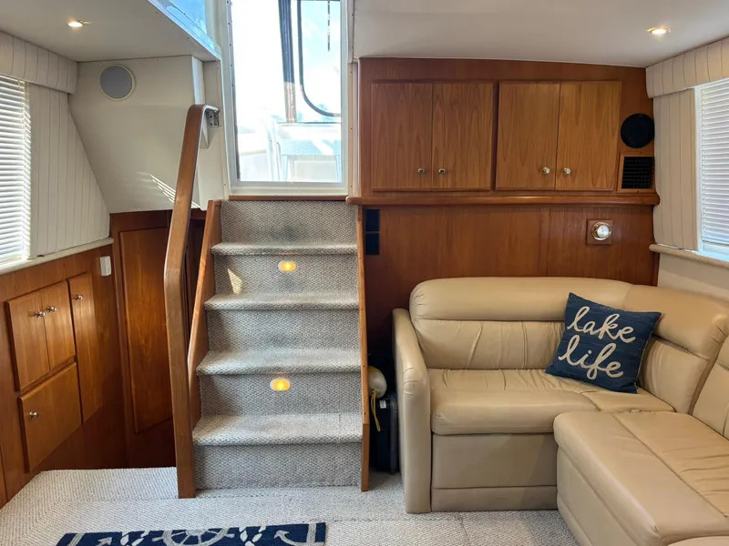 Slide: The Image of Interior of 2000 Carver 406 Aft Cabin Motor Yacht with stairs, sofa, and wooden cabinets. - 21