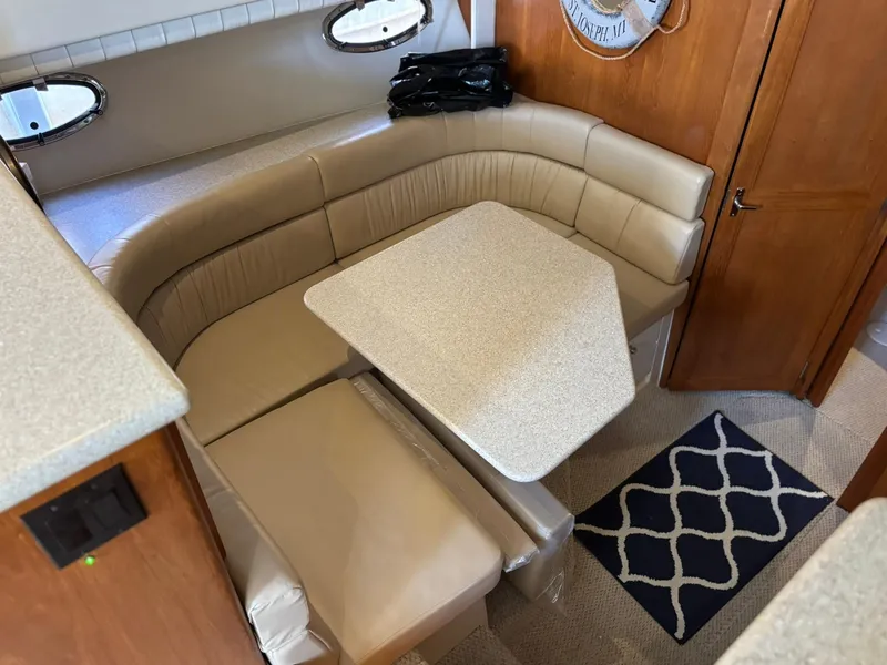 Slide: The Image of 2000 Carver 406 Aft Cabin Motor Yacht interior with beige seating and table. - 25