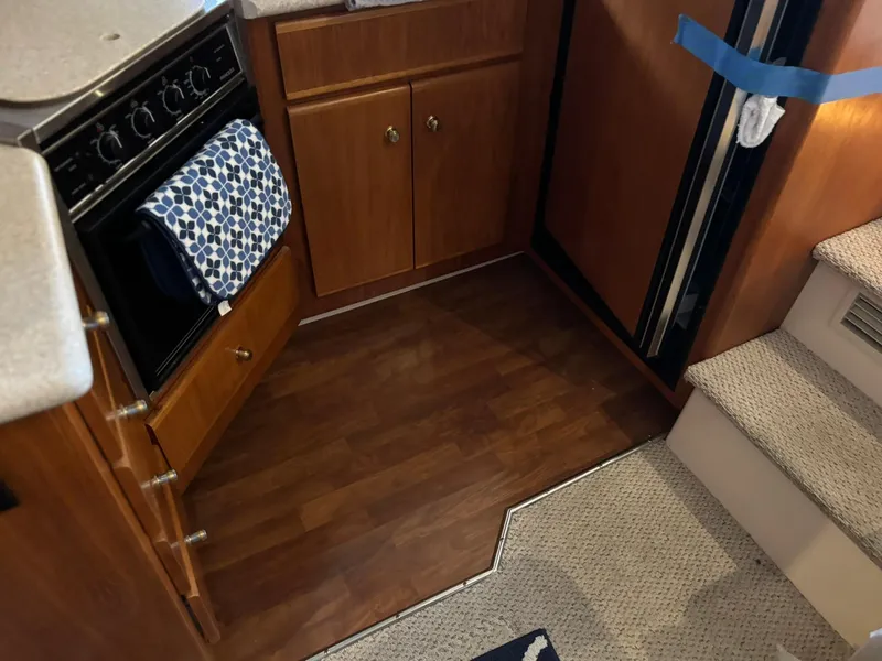 Slide: The Image of Interior of 2000 Carver 406 Aft Cabin Motor Yacht kitchen with wood cabinets and stairs. - 28