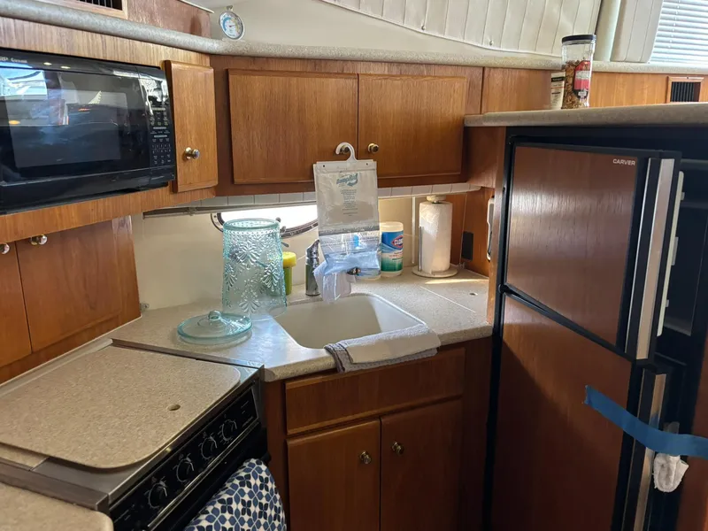 Slide: The Image of Kitchen area of 2000 Carver 406 Aft Cabin Motor Yacht with wooden cabinets and appliances. - 29