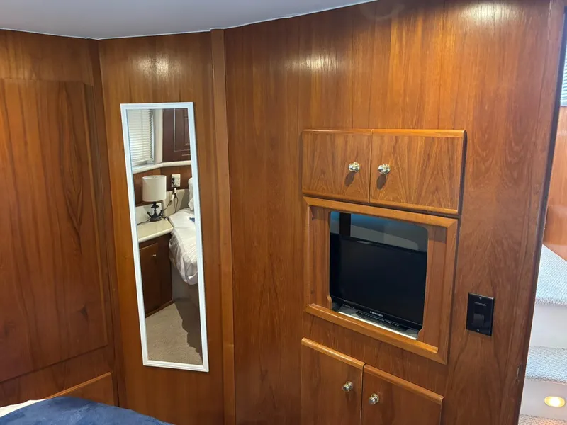 Slide: The Image of Interior of 2000 Carver 406 Aft Cabin Motor Yacht with wood paneling and built-in TV. - 37